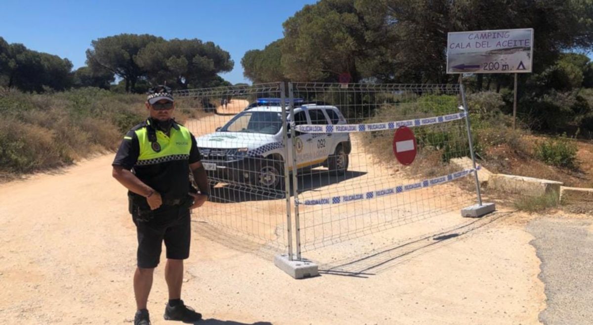 Un policía de Conil cierra el acceso a la Cala del Aceite en días atrás. FOTO: Policía Local de Conil