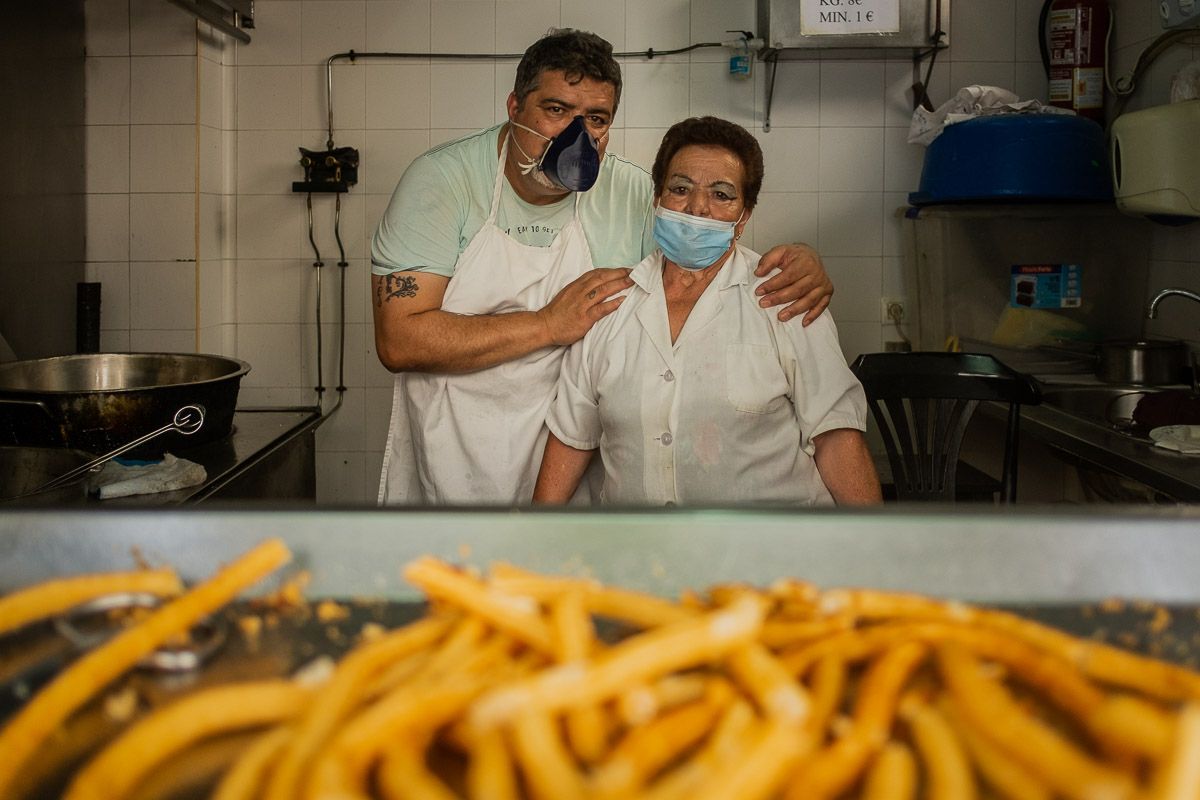 Charo Salguero junto a su hijo Alonso Romero en el puesto de churros del mercado de Abastos. FOTO: MANU GARCÍA