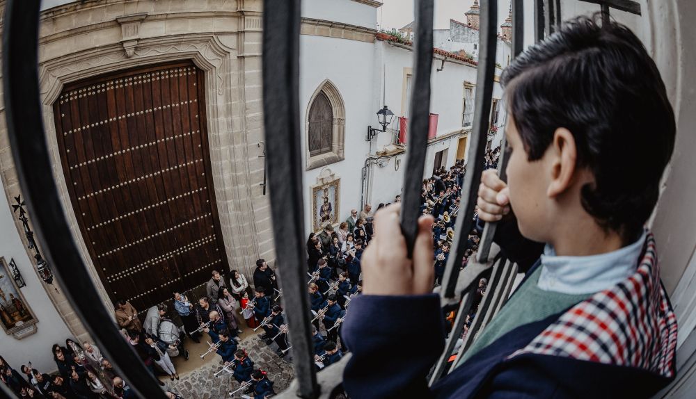Un niños mirando la puerta cerrada de la capilla del Cristo del Amor.