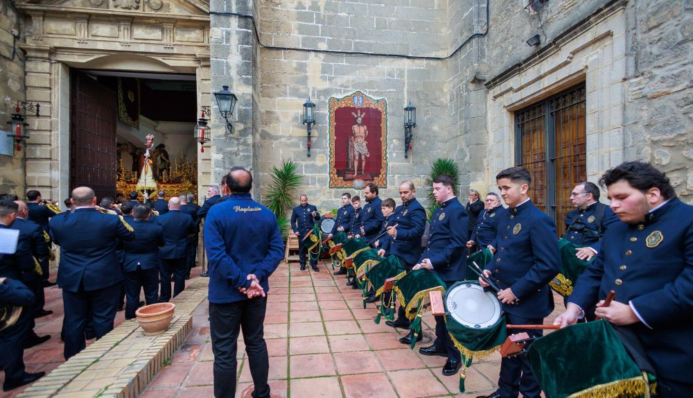 La banda de la Caridad tocando en la puerta de los Descalzos con el misterio de la Flagelación al fondo. 