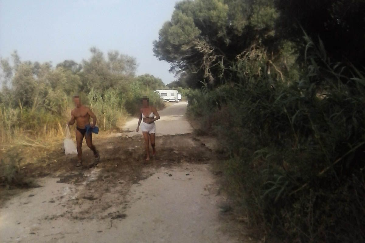 Dos bañistas en el acceso a Mangueta, tras cubrirse la zanja. 