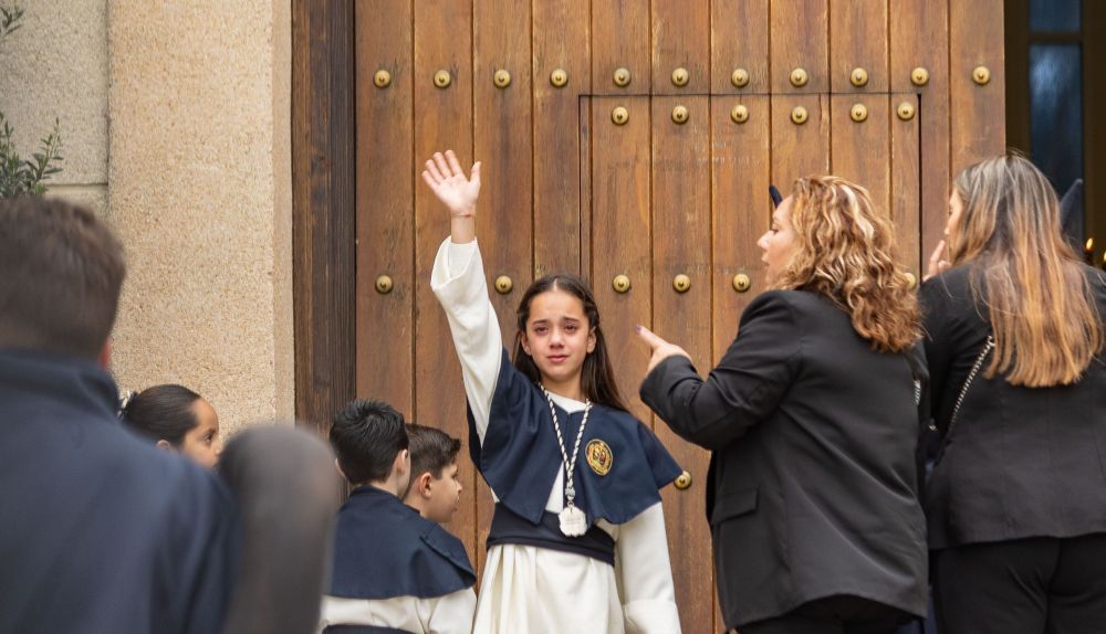 Una monaguillo de La Redención saludando desde la puerta de María Auxiliadora.