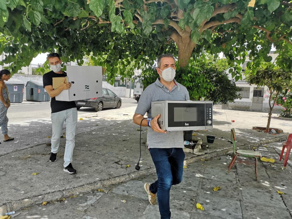 Antonio Saldaña, portavoz del PP, llevando un microondas a una vecina de Jerez.