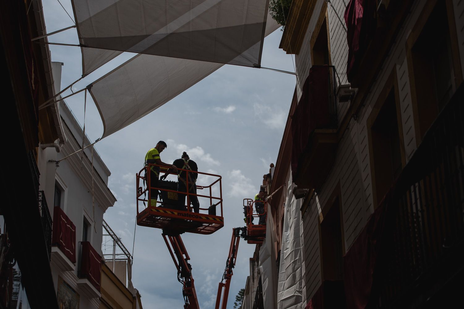 Una empresa instalando toldos en el centro de una ciudad para crear sombra.