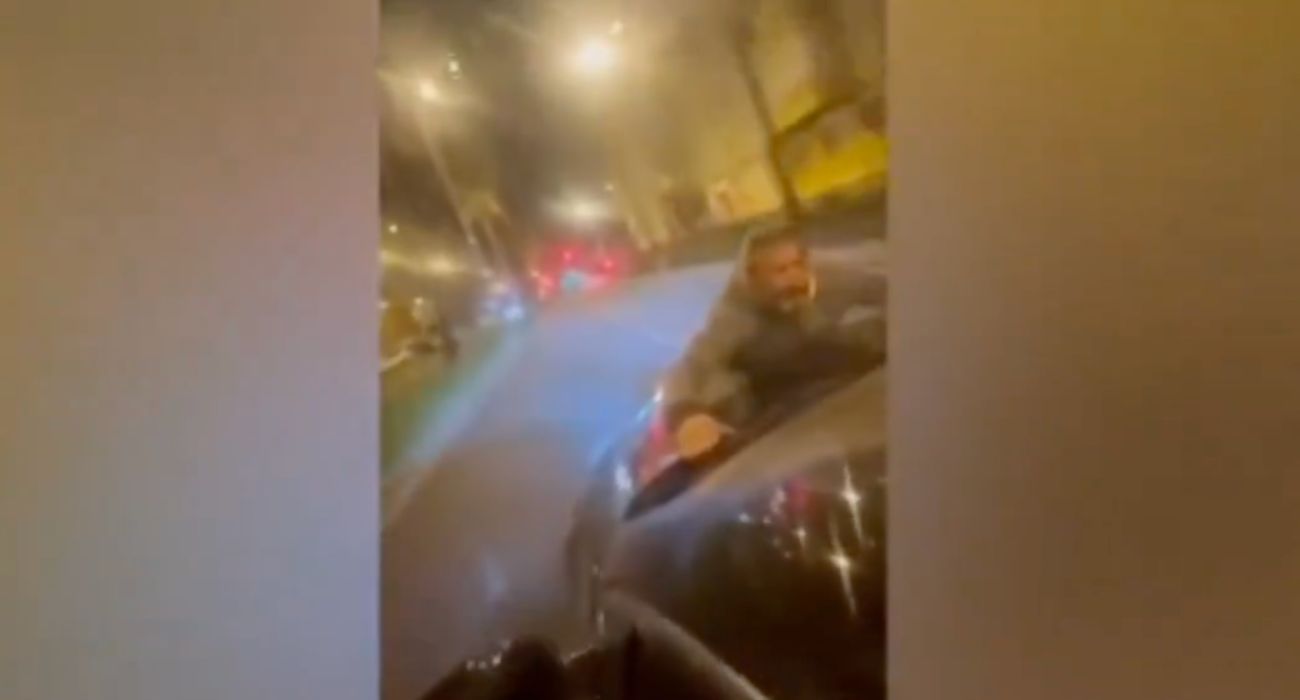 Un hombre, en lo alto de un capó de un coche, mientras el vehículo está en marcha. Un hombre, en lo alto de un capó de un coche, mientras el vehículo está en marcha.