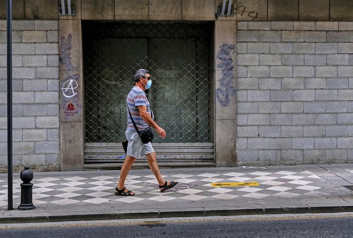Un hombre pasea por la calle con mascarilla en Granada. FOTO: JOSÉ LUIS TIRADO