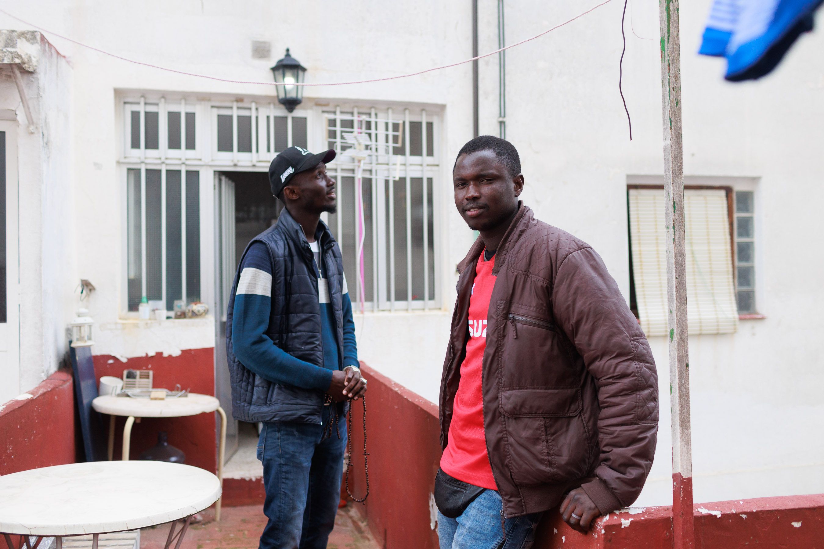 Lamine y Malick, jóvenes migrantes, en el piso conseguido por Dimbali.