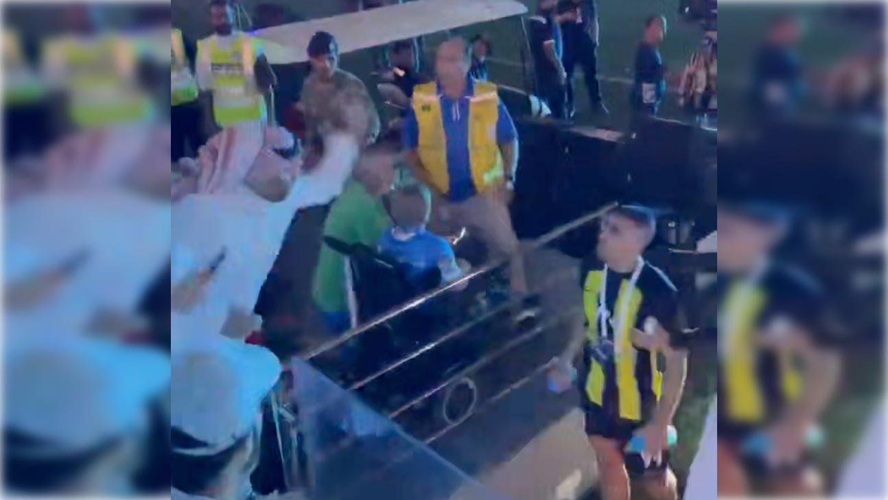 El aficionado, agrediendo con un látigo al futbolista.