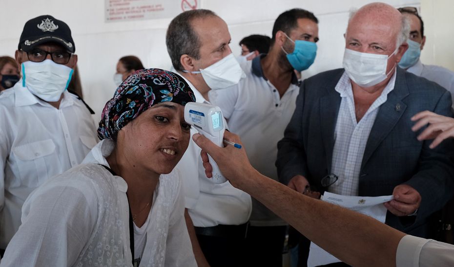 El consejero Jesús Aguirre observa como toman la temperatura a una temporera este pasado mes de julio.