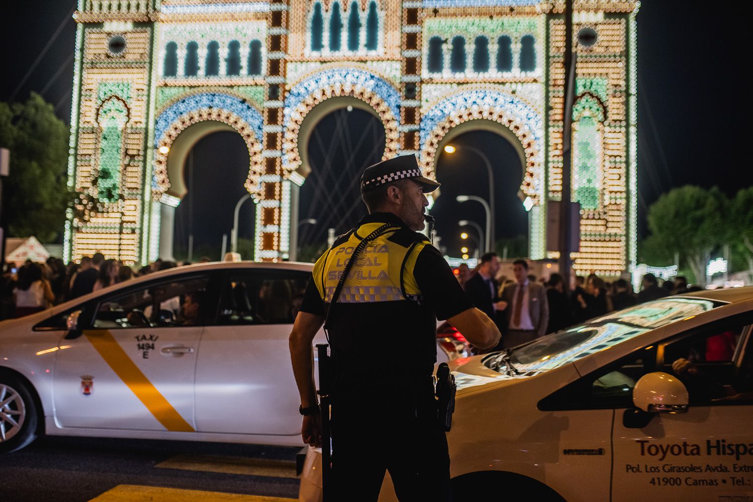 Un agente de Policía en la portada de la Feria de Sevilla dando paso a los taxis.