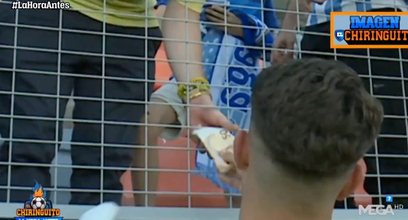 El jugador del Málaga, cogiendo un billete de 50 euros a un aficionado por su camiseta.