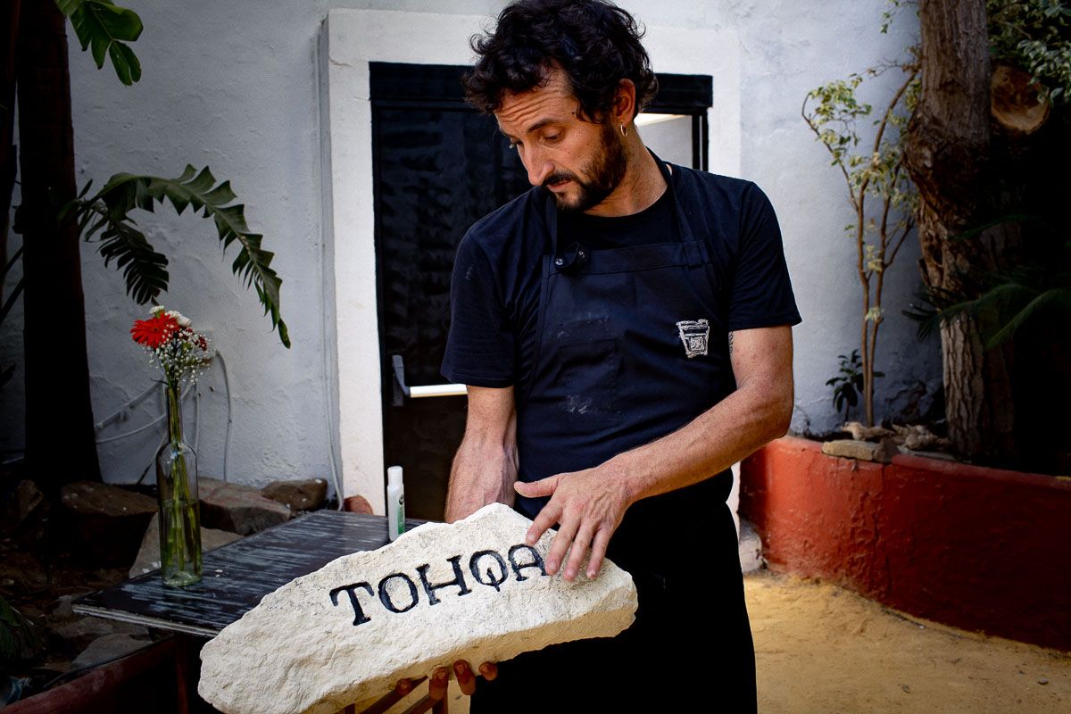 Edu Pérez sujetando la 'tohqa' colocada a la entrada del restaurante. FOTO: JUAN CARLOS TORO