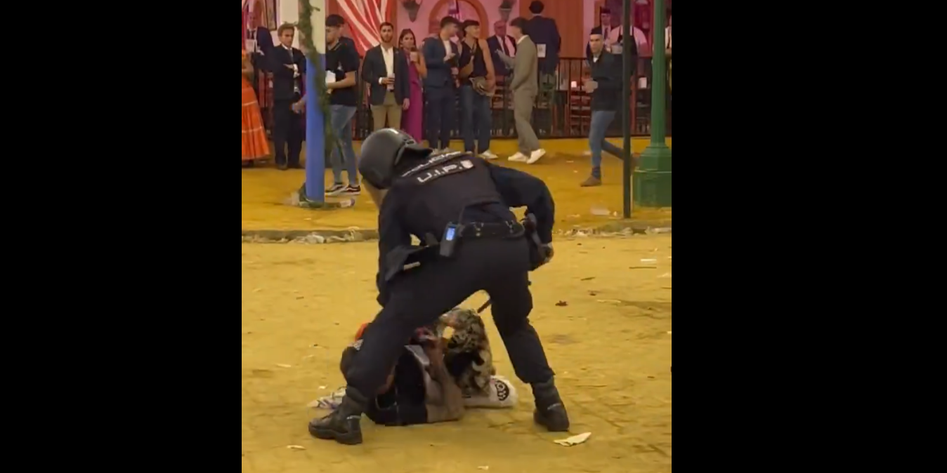 Un agente de Policía Nacional interviene en la pelea de esta madrugada en la Feria de Sevilla.