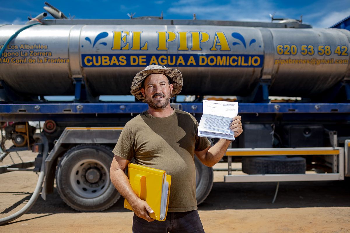 Juan Antonio Brenes, 'El Pipa', mostrando una de las multas recibidas delante de su camión cisterna. FOTO: JUAN CARLOS TORO