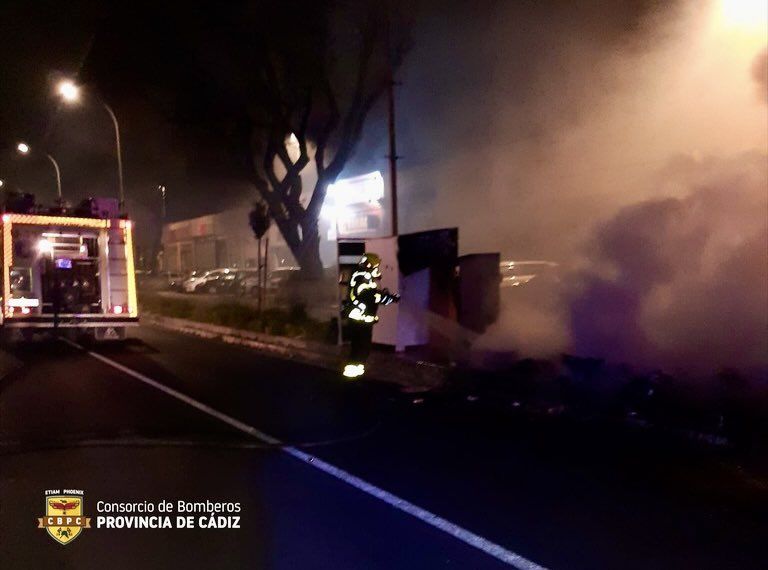 Un bombero actúa en uno de los incendios de contenedores y coches en El Puerto, esta madrugada.