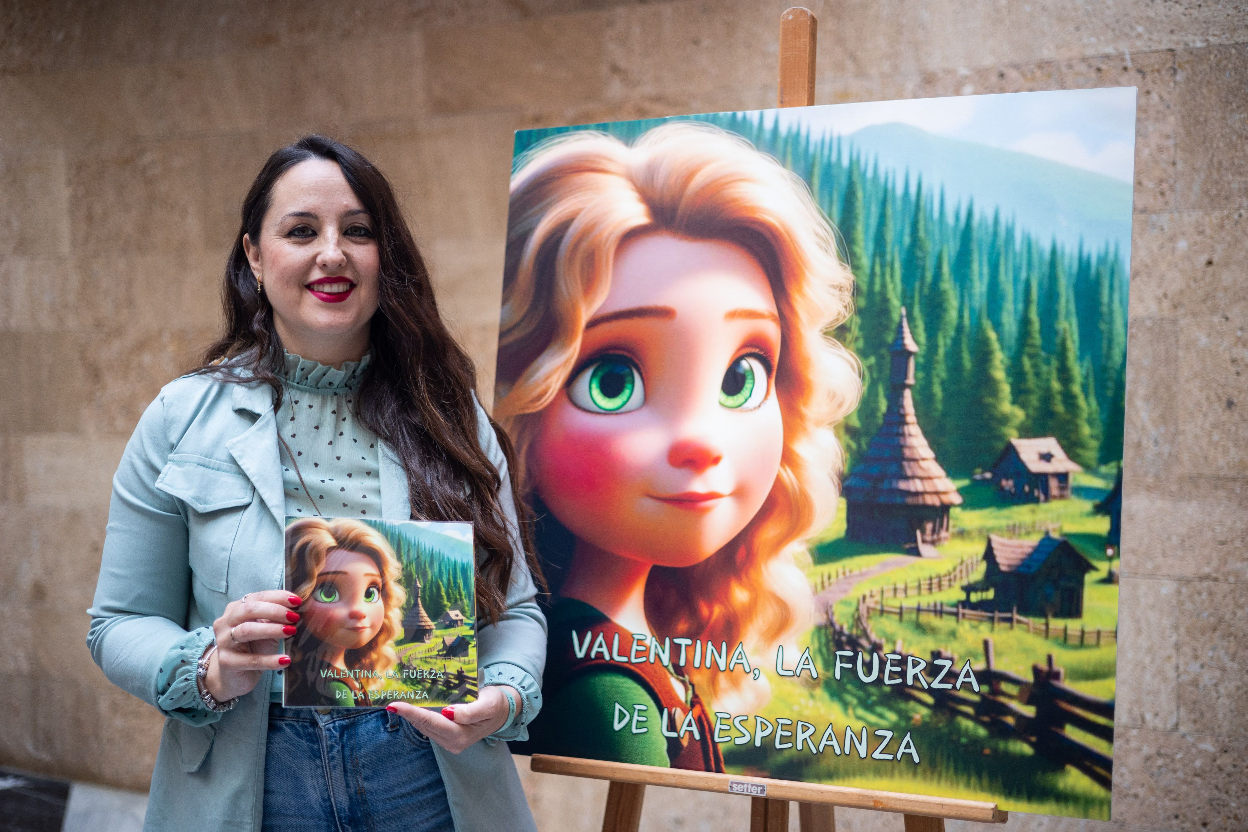 Tamara Romero, madre de la pequeña Valentina, posando con el libro infantil. 