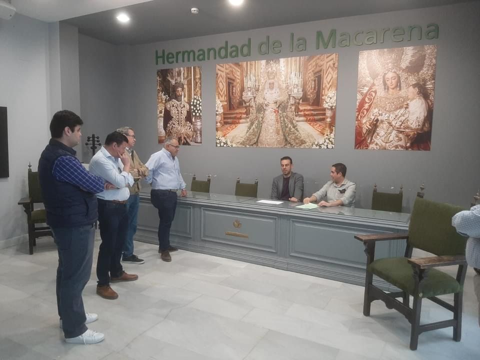 El hermano mayor y el director de la banda firmando el contrato en la sede de La Macarena en Sevilla.