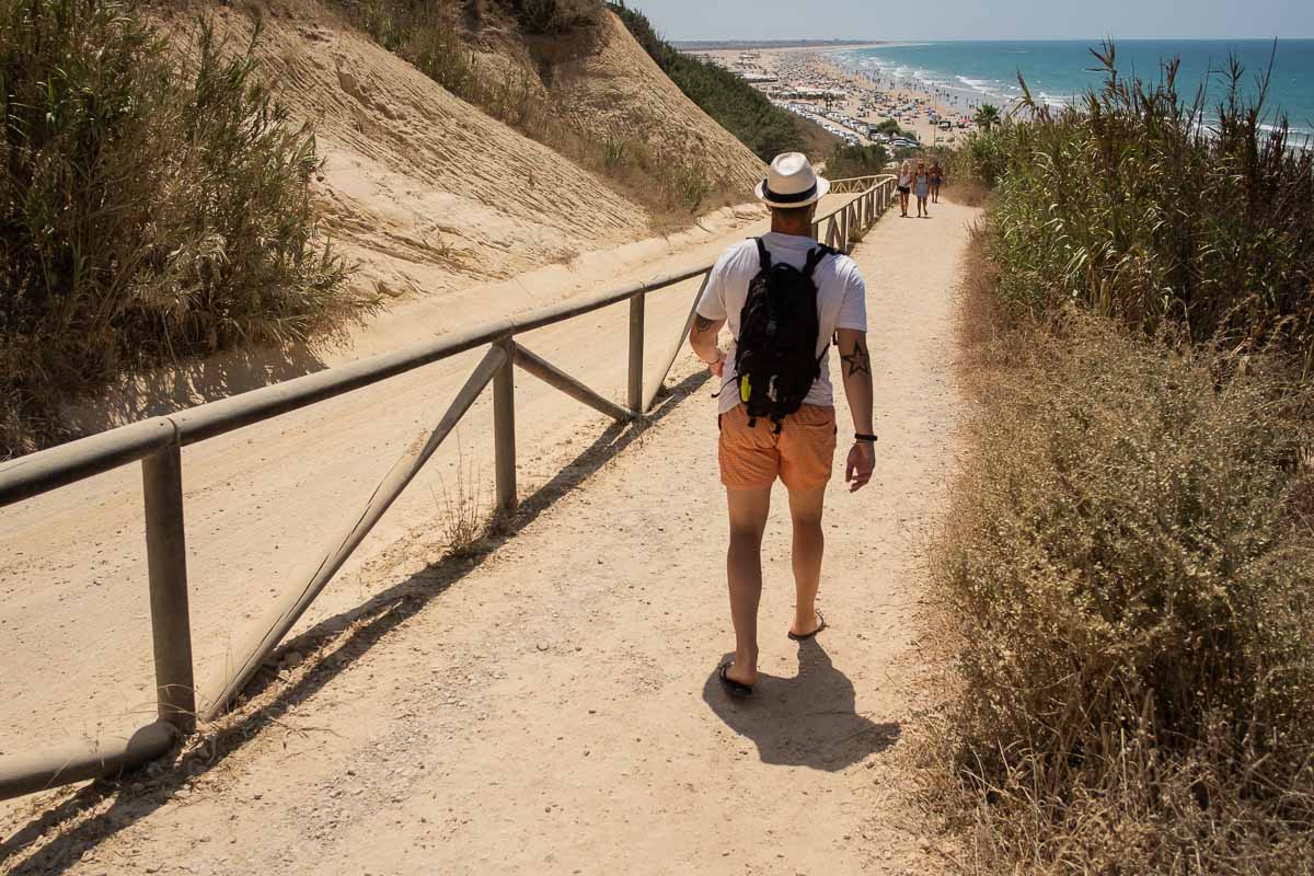 Un hombre baja hacia la playa de La Fontanilla en Conil, una de las libres de humo en la provincia de Cádiz.