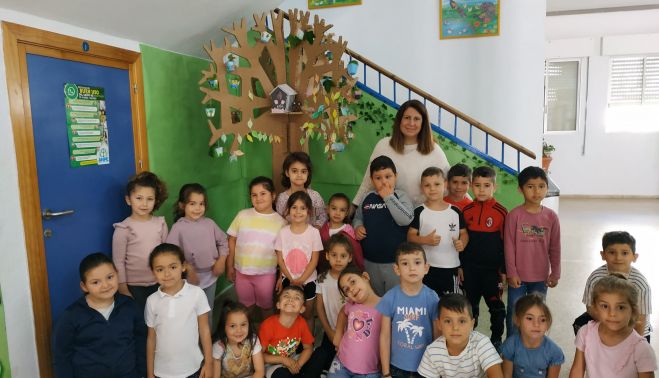 Alumando del Sagrada Familia junto al resultado del taller de manualidades de casita de pájaros.