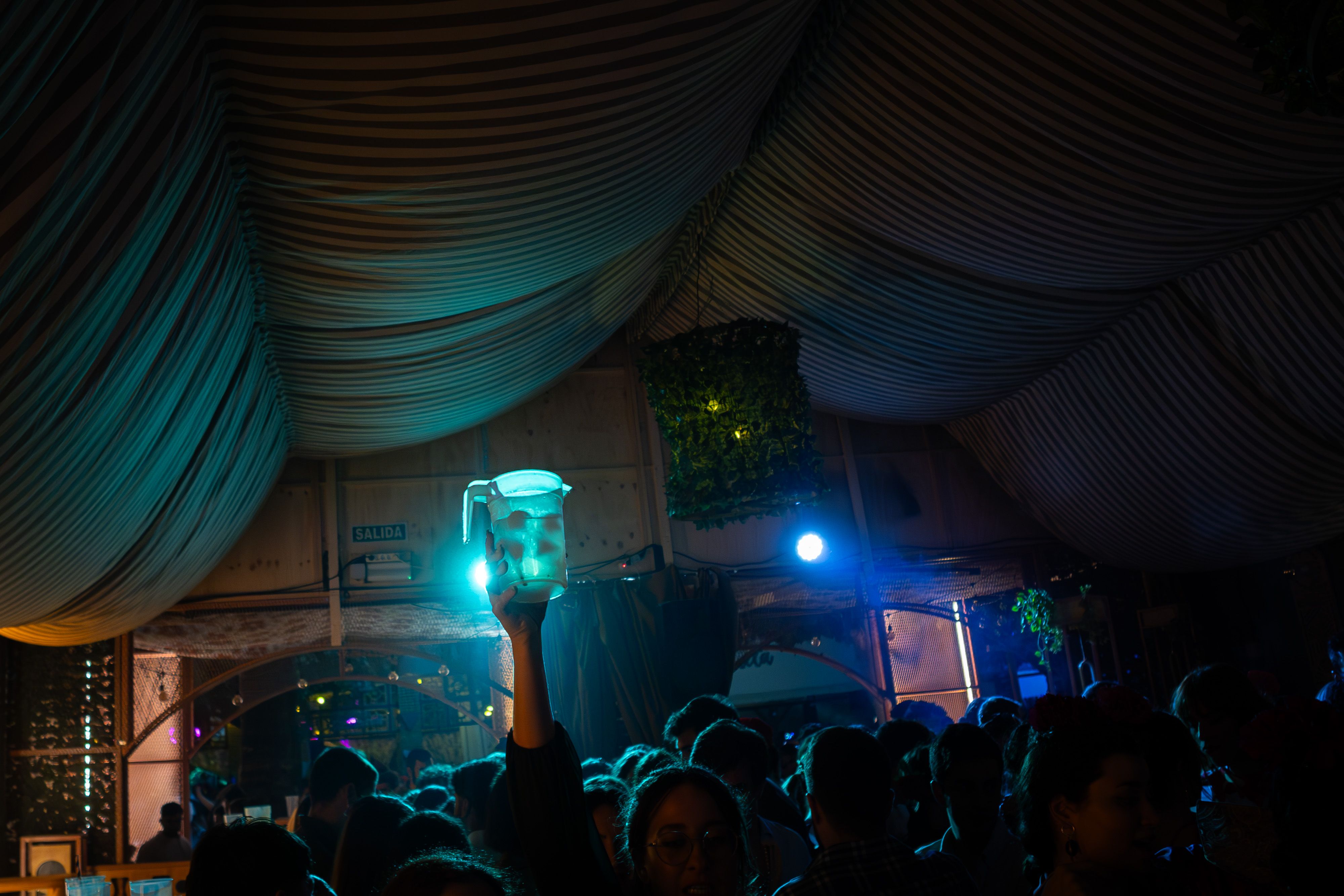 Interior de una caseta-discoteca en esta Feria de Jerez 2024, con una jarra de rebujito tratando de abrirse paso entre la multitud.