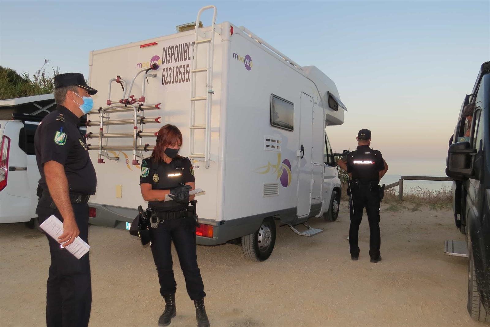 La policía, sancionando a autocaravanas aparcadas de forma ilegal en una fotografía de archivo.