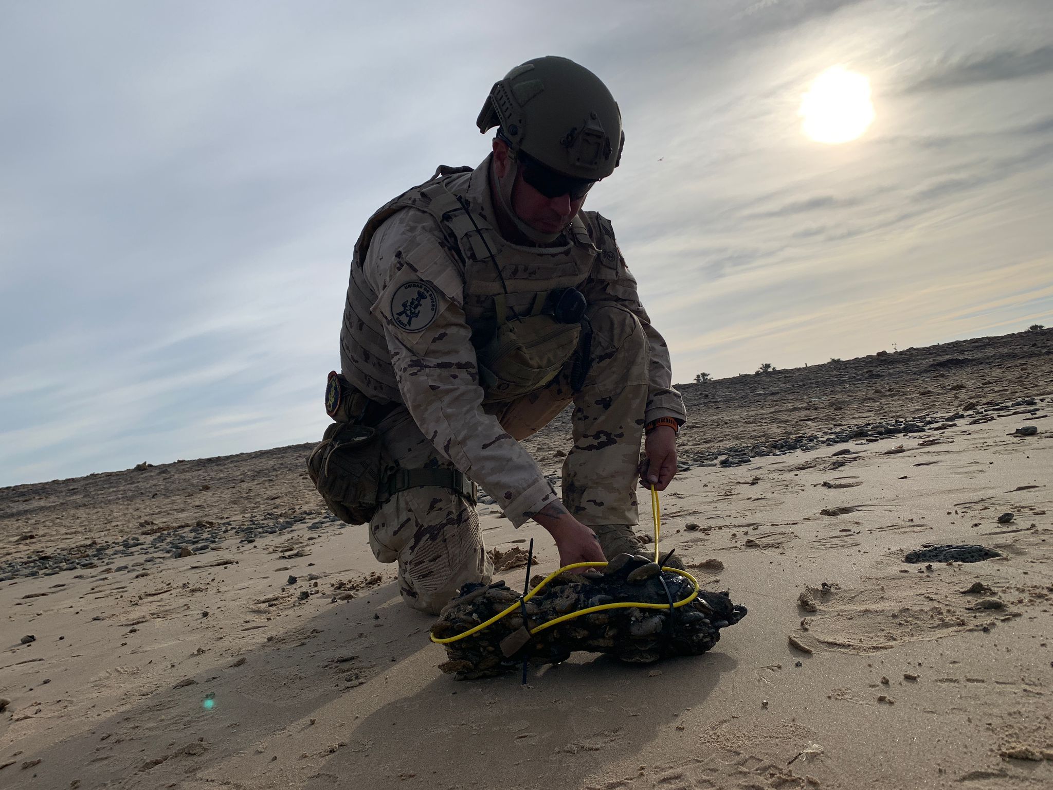 Un operador de la Unidad de Buceo de Cádiz desactiva un proyectil en la playa de Camposoto, en San Fernando.