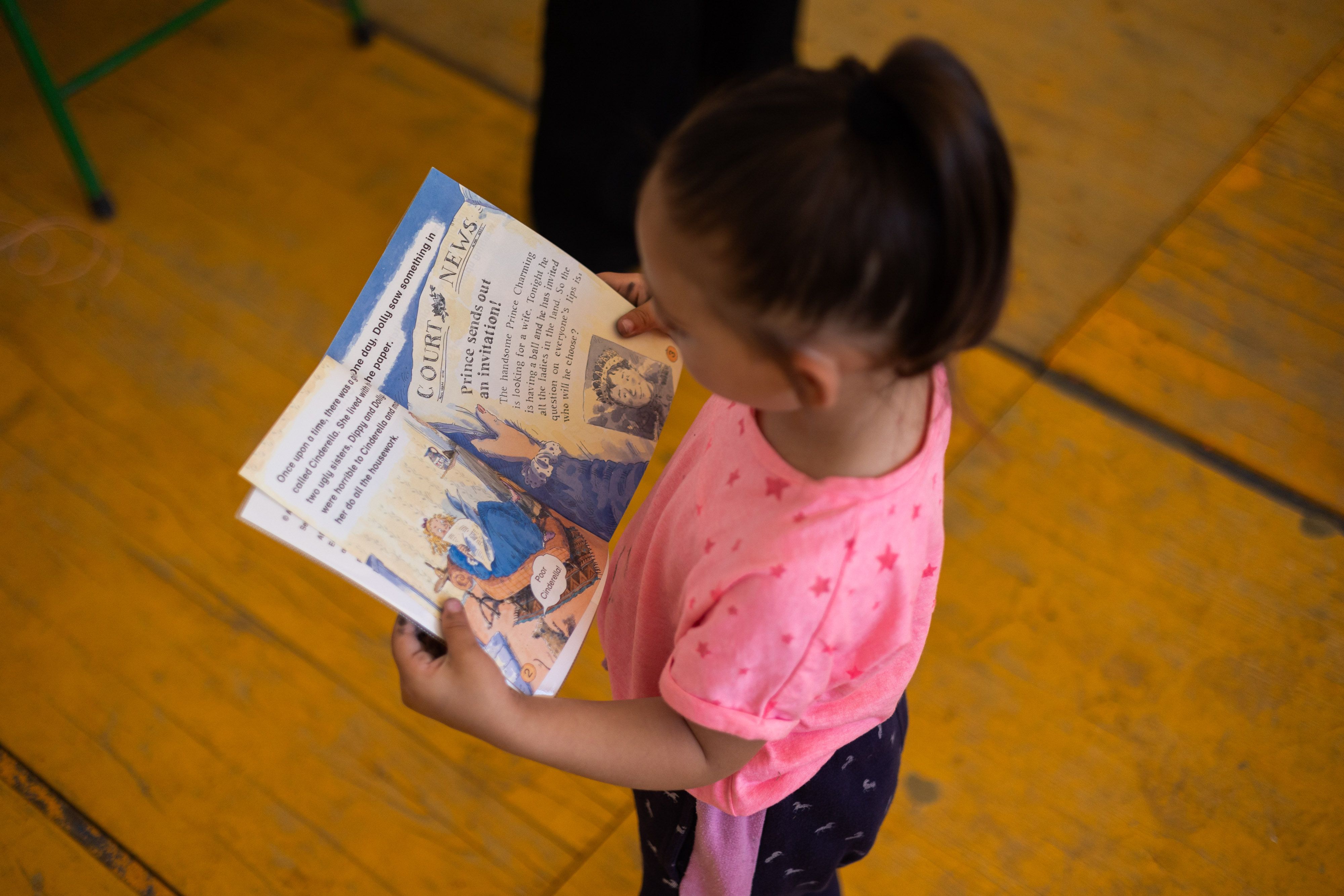 Una niña lee un cuento en la sede de Brote de Vida.