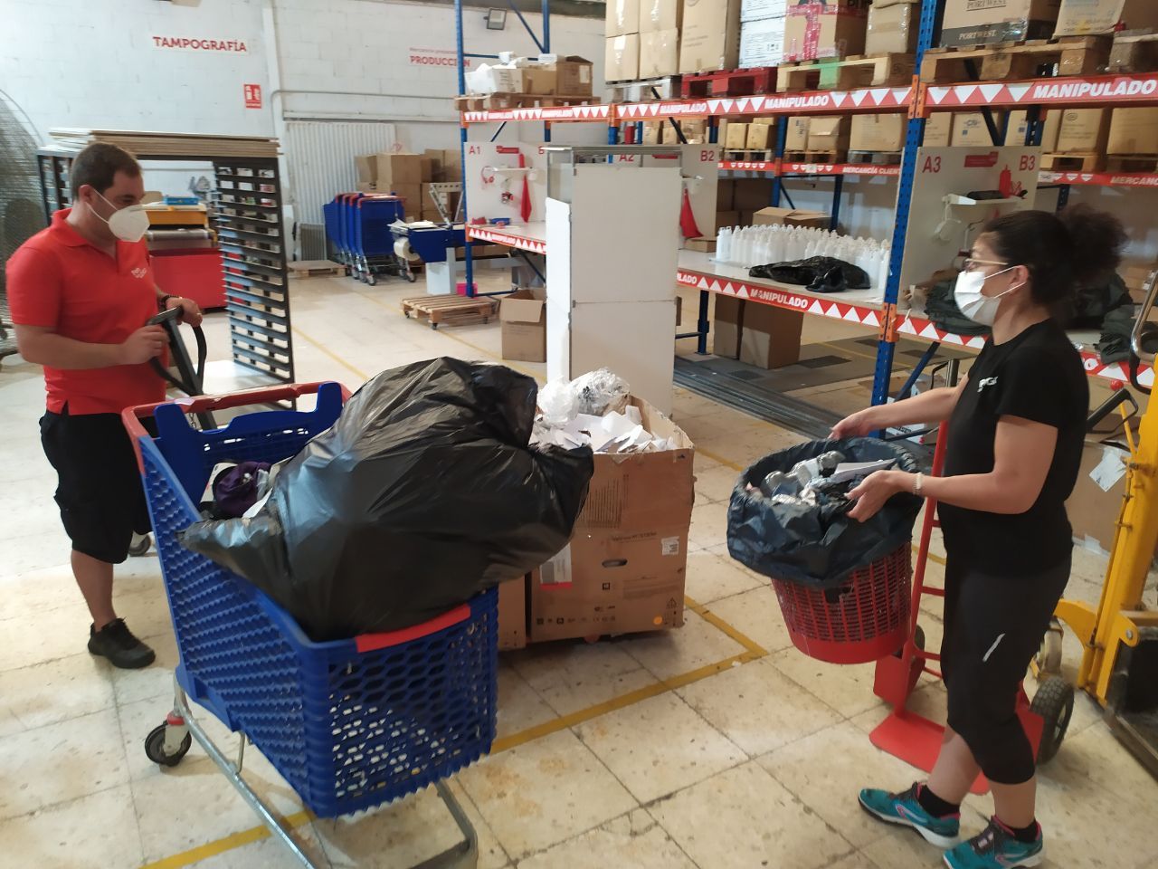  Los trabajadores de Pon tu logo preparan las bolsas de basura en carros para trasladarlas al contenedor más cercano.