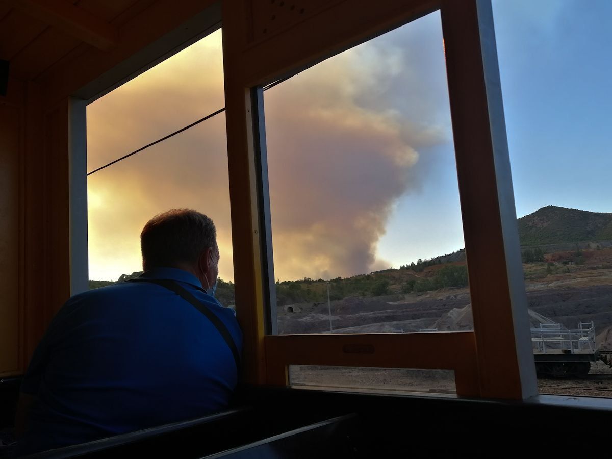 Un hombre observa por una ventana el incendio declarado en Almonaster. FOTO: MANU GARCÍA