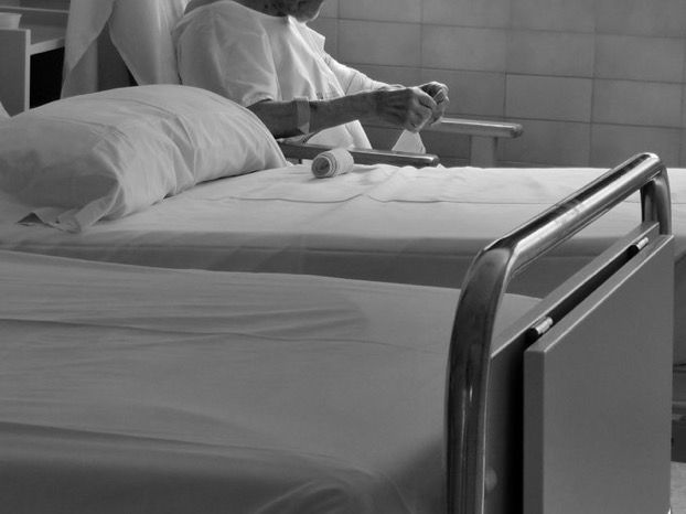 Una persona mayor, en una habitación de hospital.