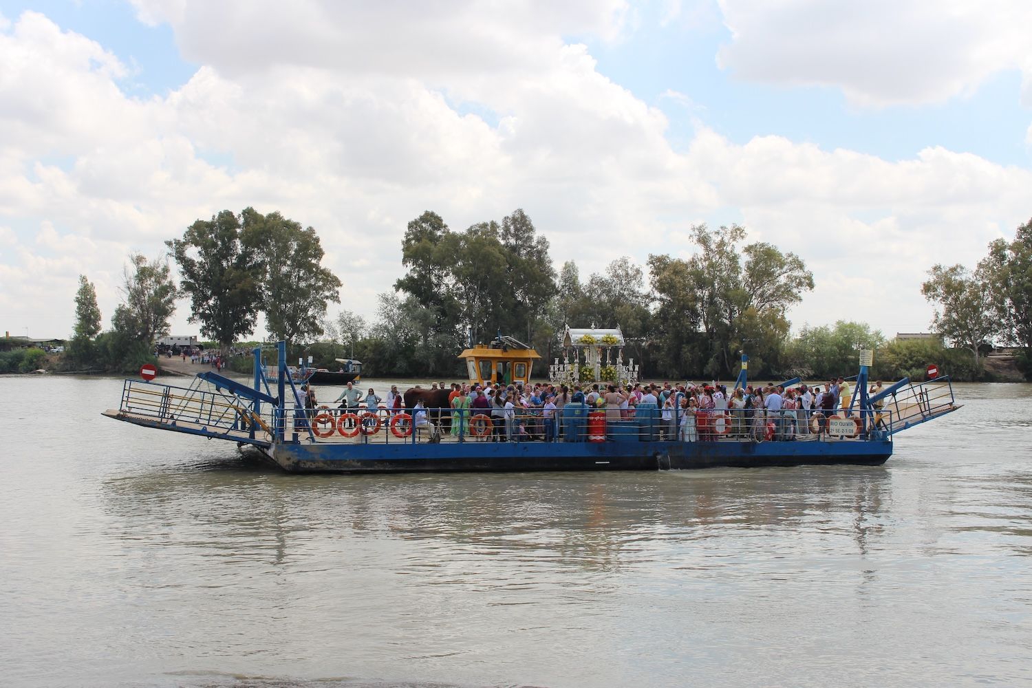 Momento del cruce de una hermandad por Coria del Río en la barcaza. Momento del cruce de una hermandad por Coria del Río en la barcaza.