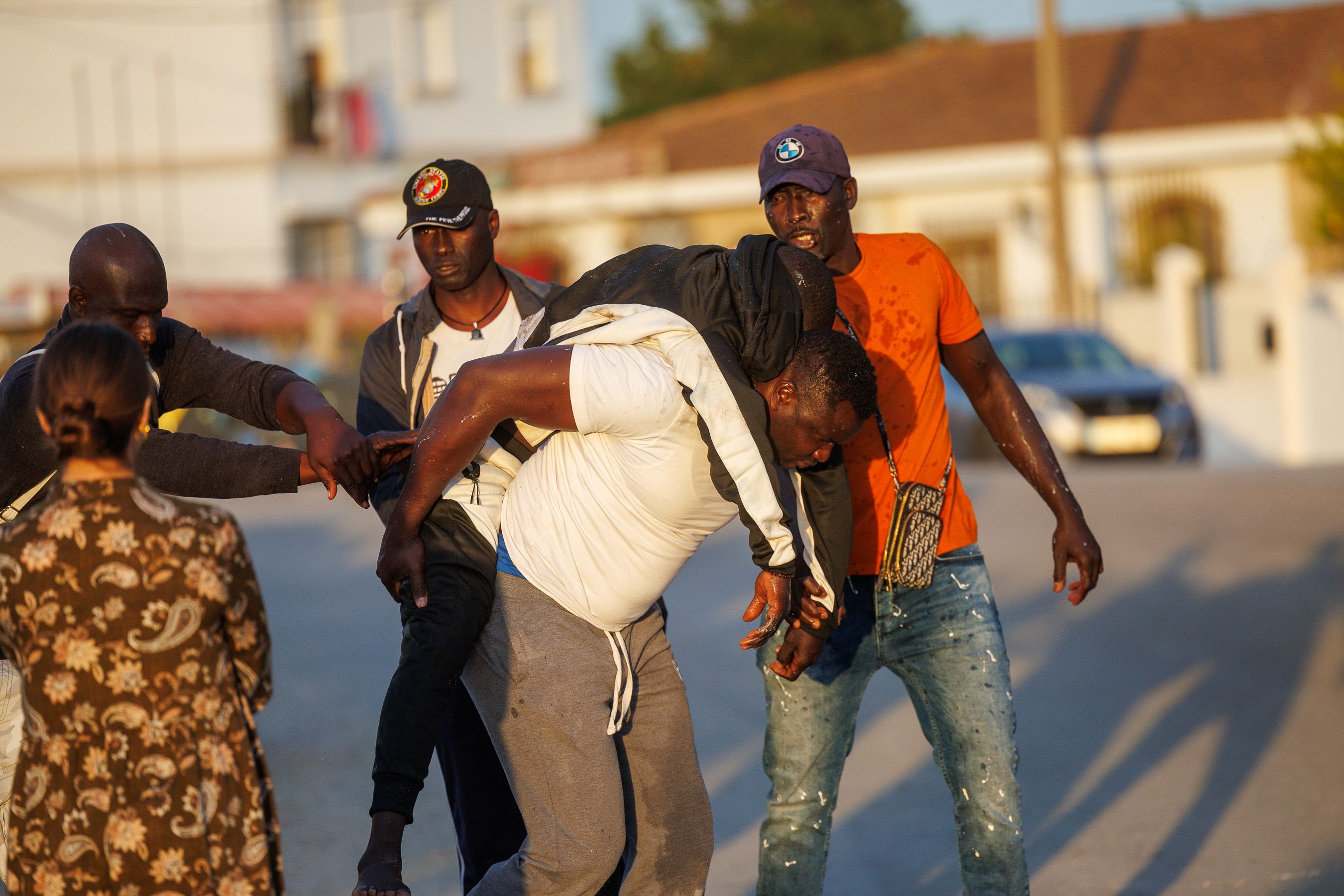 Un hombre porta a Pape, desplomado, tras una tarde de tensión a las puertas de un centro de acogida de migrantes en Cuartillos, Jerez, este pasado jueves.