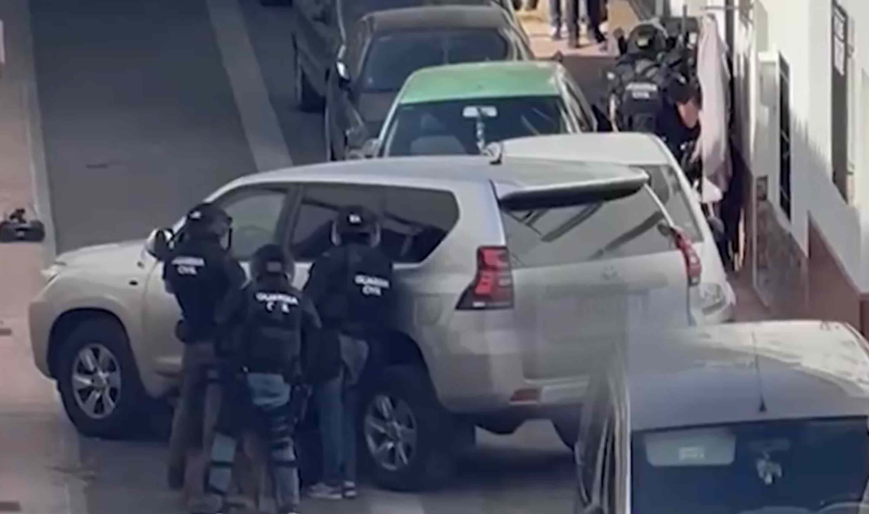 Agentes de la Guardia Civil, apostados ante la casa de Campillos donde permanece atrincherado un hombre, en una imagen difundida en redes sociales.