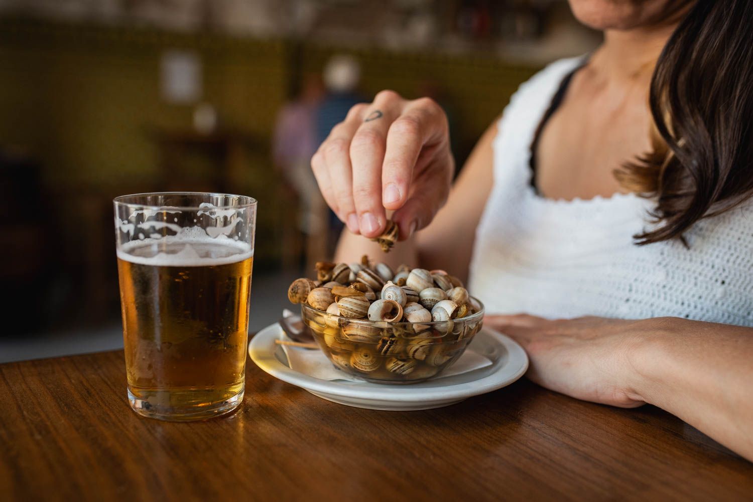 Una mujer comiendo caracoles en un bar andaluz. Una mujer comiendo caracoles en un bar andaluz.