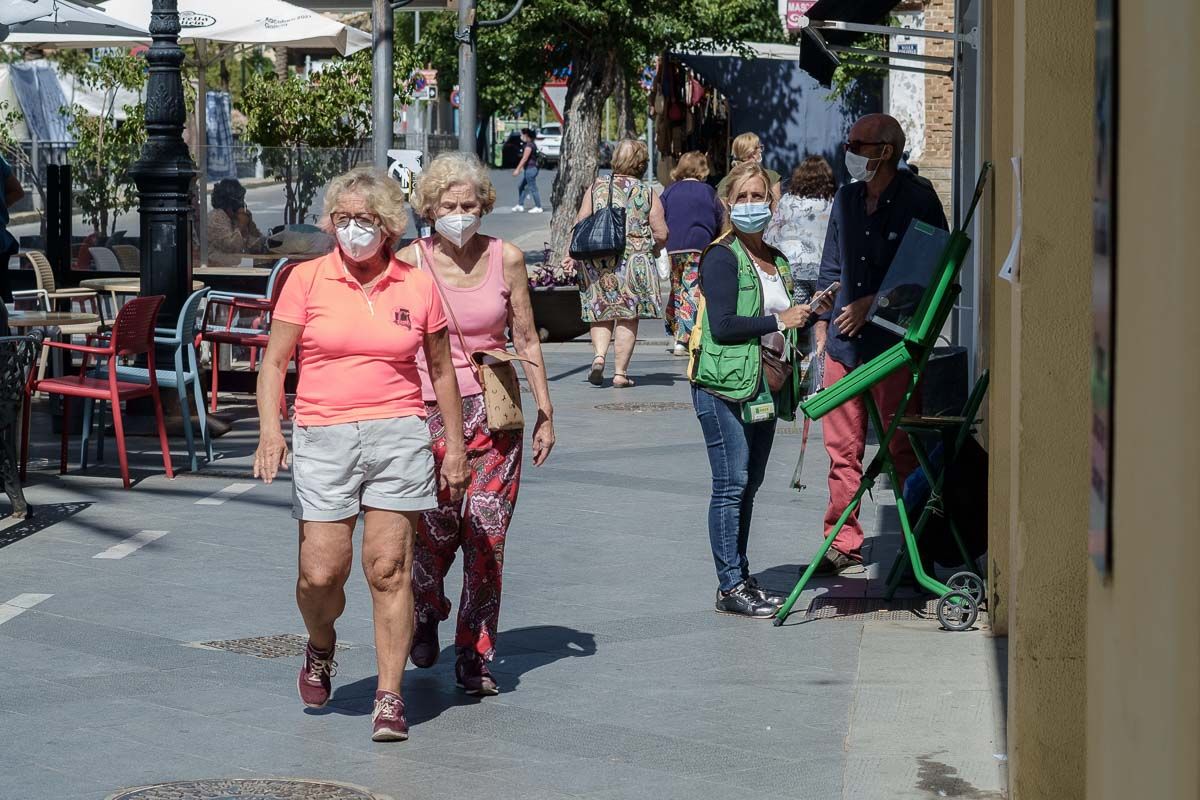 Varias personas pasean con mascarillas por las calles de Sanlúcar antes del 9 de mayo.