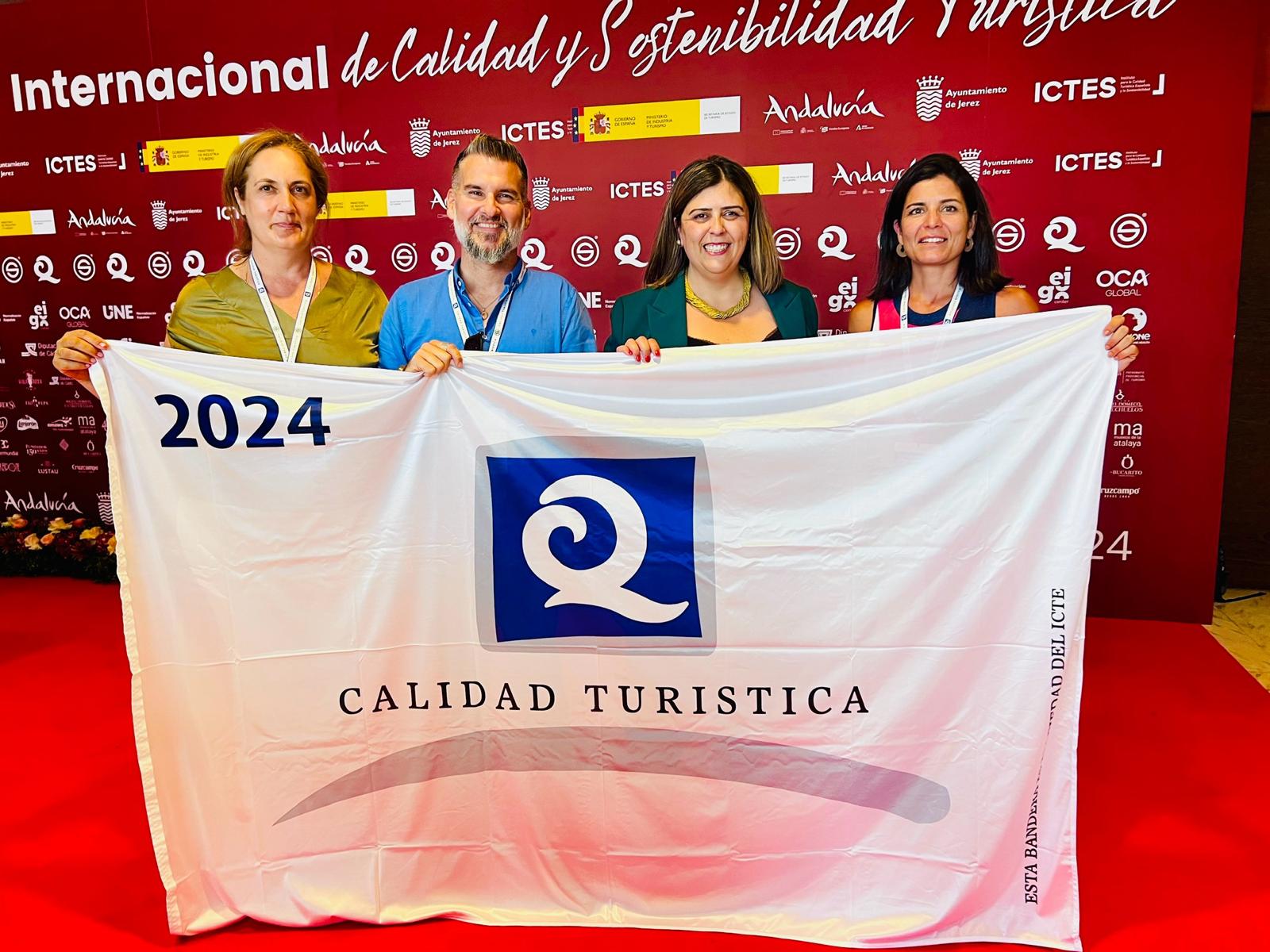La alcaldesa y responsables de turismo de la localidad con la bandera que lucirán las dos playas.
