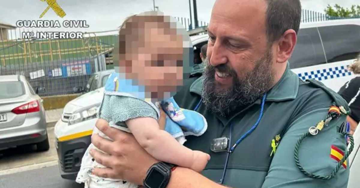 Un agente de la Guardia Civil, tras rescatar a un bebé del interior de un vehículo.