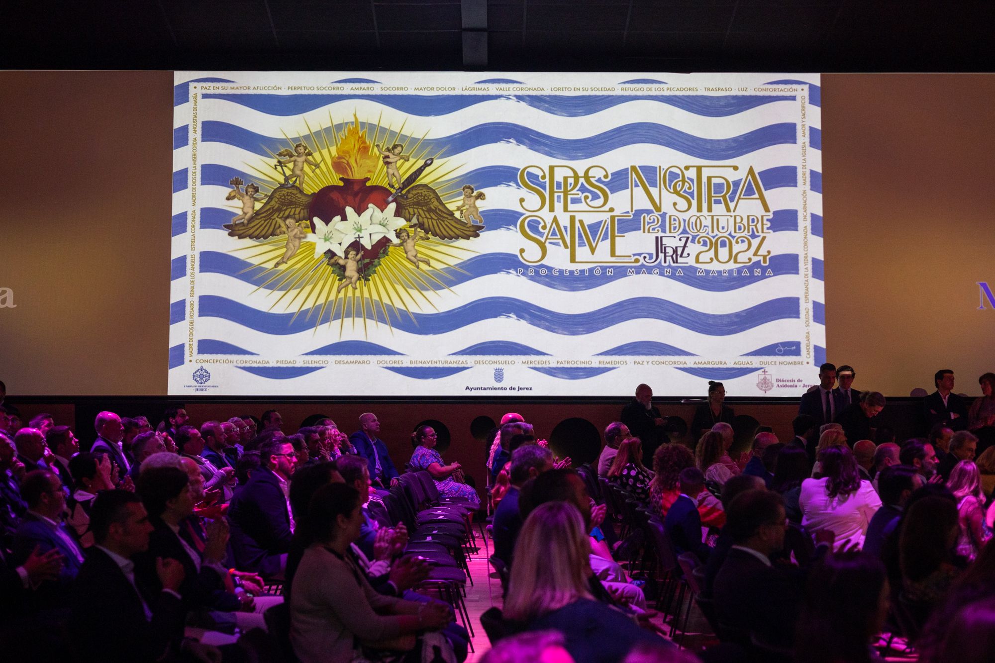 La versión horizontal del cartel proyectado en las pantallas de la sala.