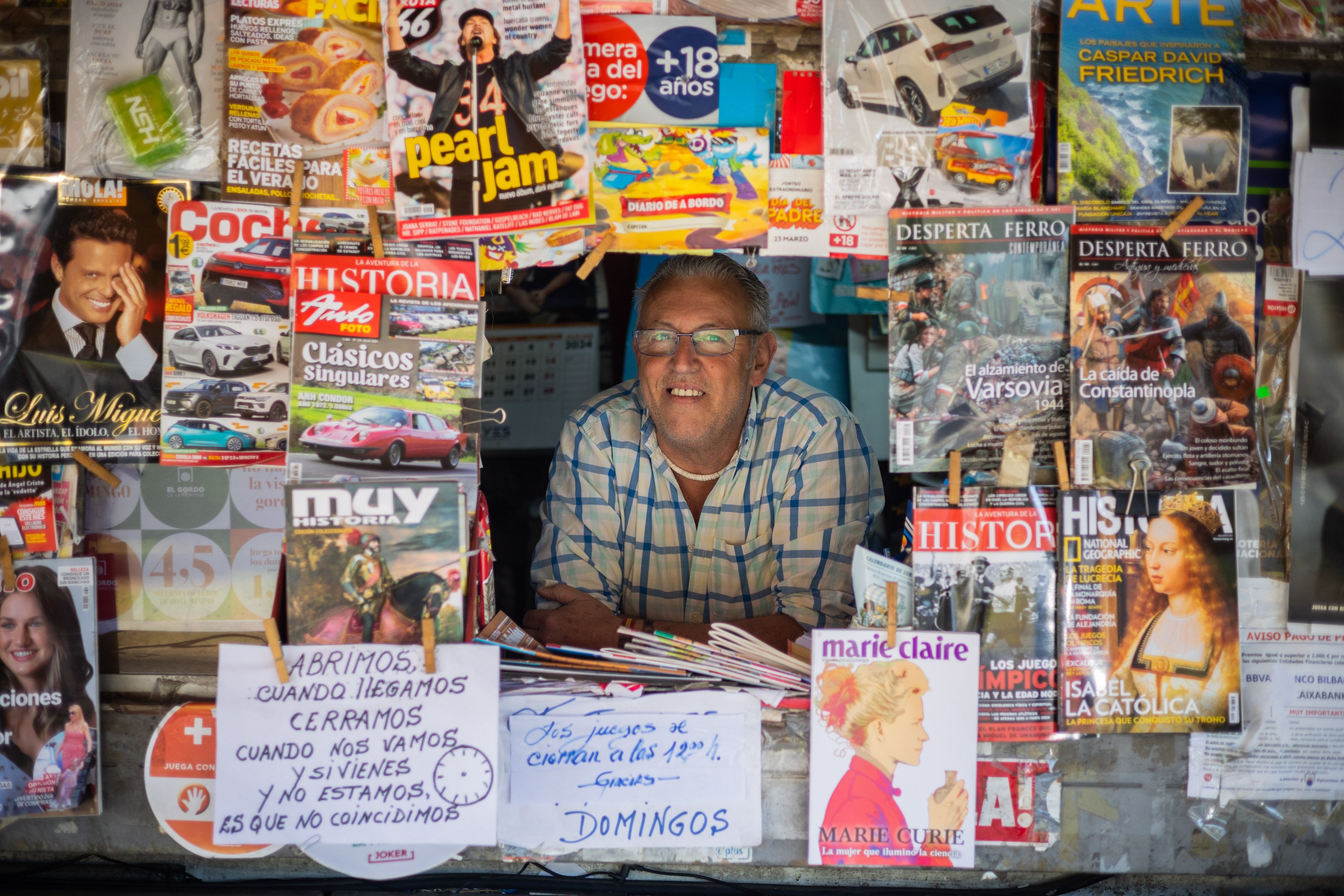 Paco asomado al ventanuco que le queda después de colocar todo el género, un marco en el que cuelga algún simpático cartel.