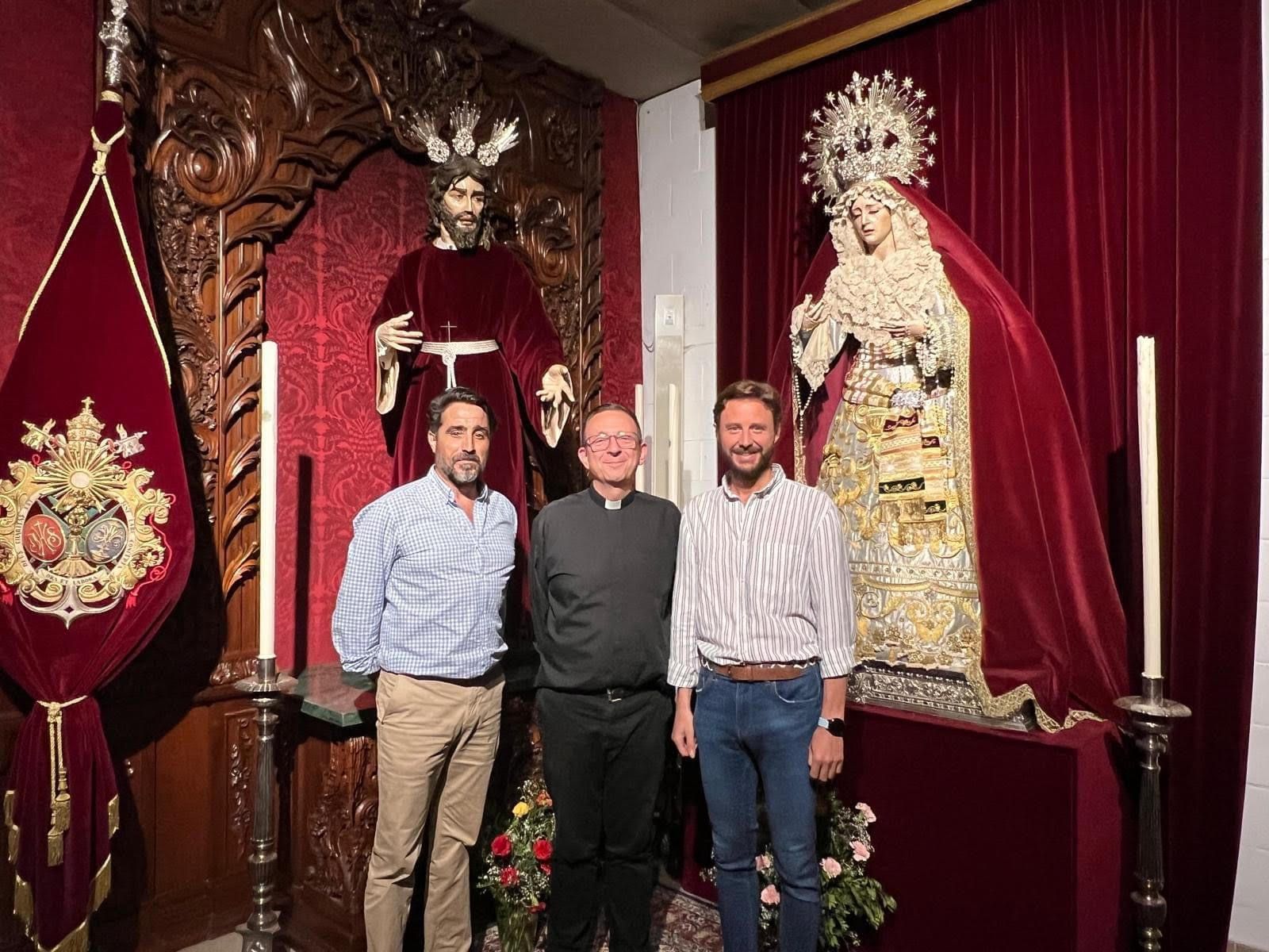 David Guerrero, a la izquierda, junto al párroco y, a la derecha, el hermano mayor saliente. 