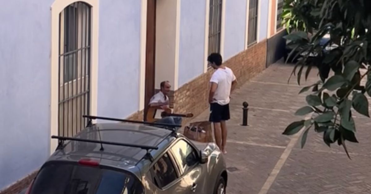 El joven estudiante, despidiéndose del músico callejero.