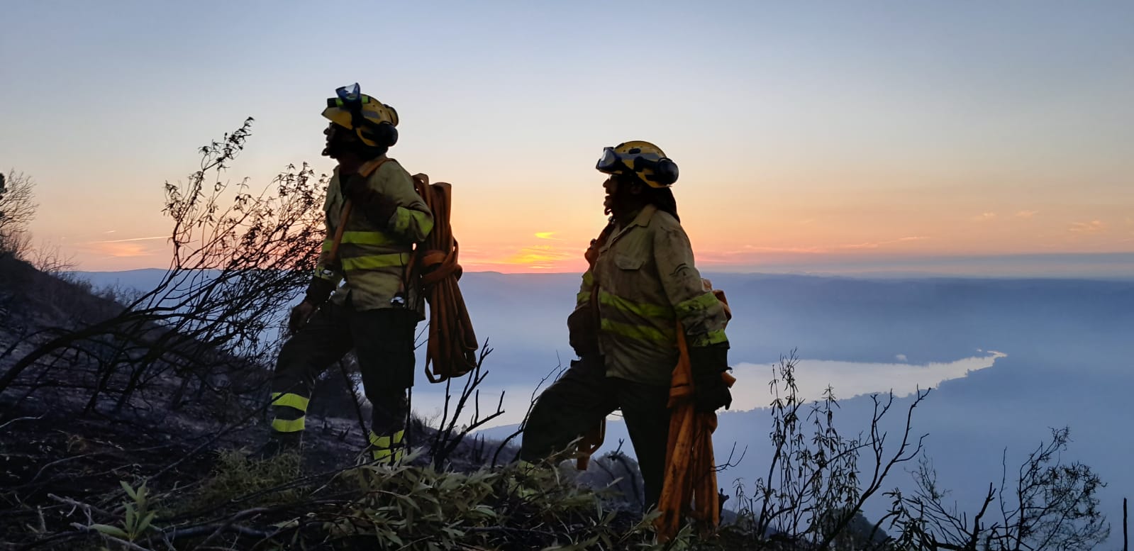 Dos de los bomberos del Infoca trabajando en la extinción de un incendio.