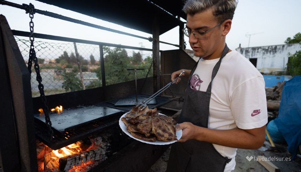 Un camarero de El Chinchal con un plato de sardinas.