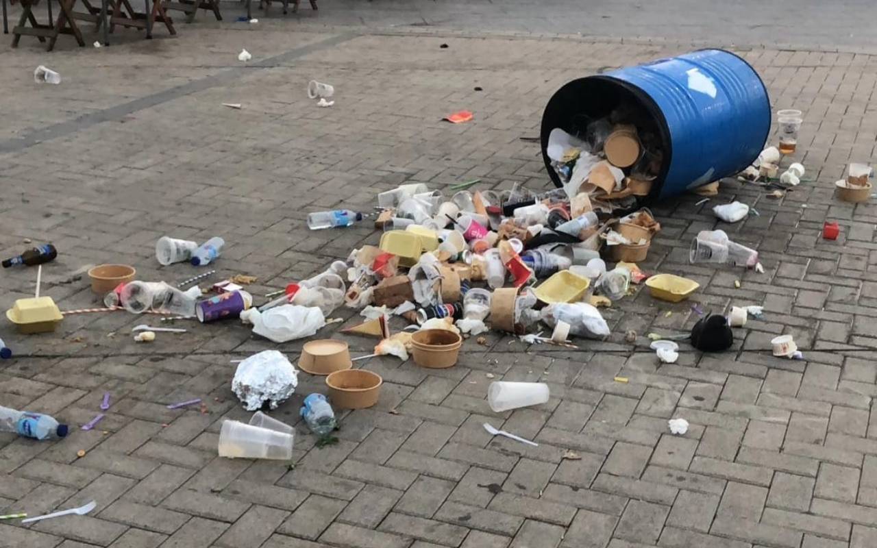 Una papelera tirada en el suelo, desbordada de residuos, en una imagen compartida por el Ayuntamiento de La Línea.