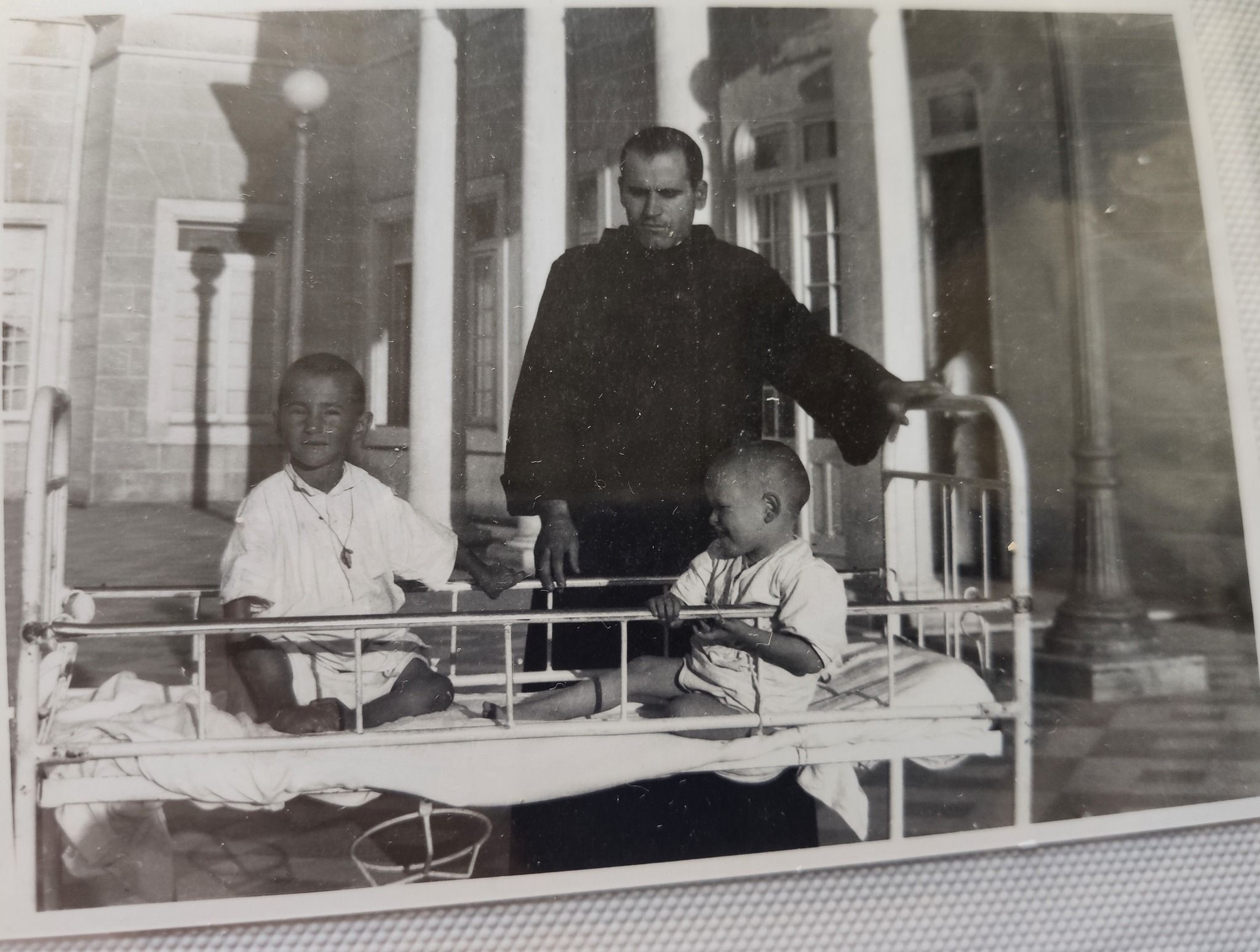 Un hermano junto a dos niños en el Sanatorio de los hermanos de San Juan de Dios en Jerez.
