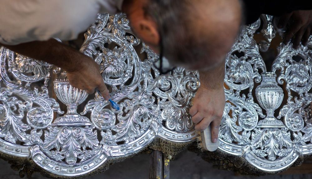 Un hermano con un cepillo de dientes afinando la limpieza entre los recovecos del trabajo de orfebrería. 