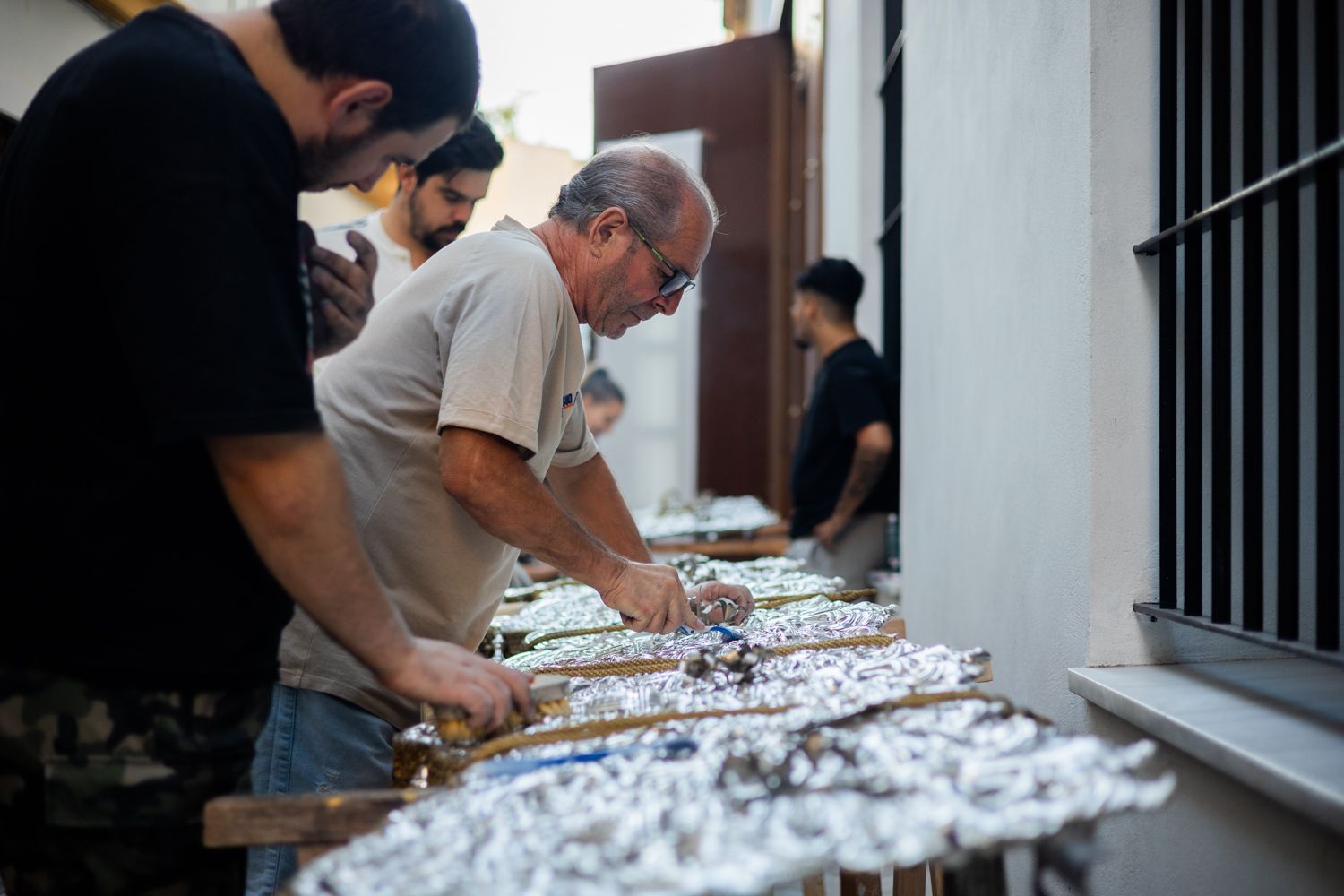 Limpiando la plata como si fuera Cuaresma. Hermanos de La Cena trabajando en la limpieza de las caídas del palio. 