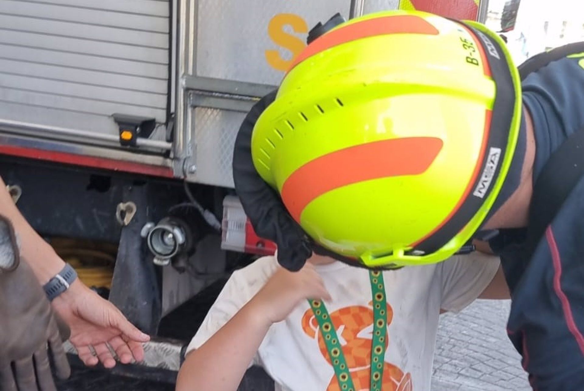 El niño, hablando con uno de los bomberos que lo ha sacado de la atracción.