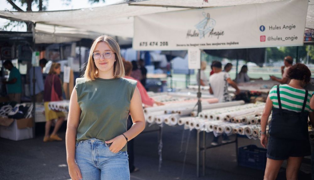 Carla, delante del cartel ubicado en el puesto.