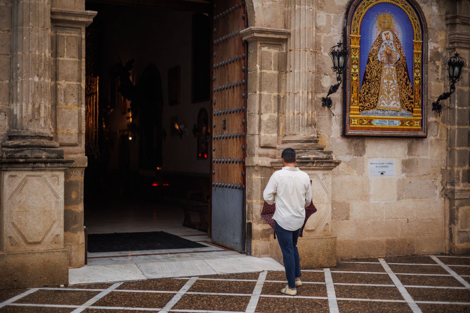 Una persona entrando con un paraguas en una iglesia de Jerez.